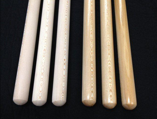 Six wooden broom and mop handles with a clear lacquer finish and tinted maple stain